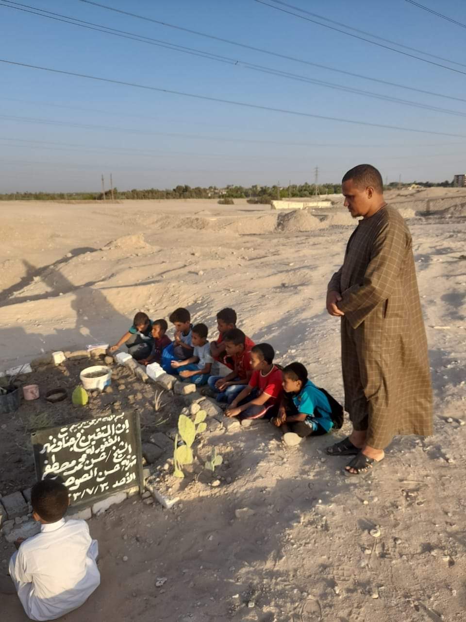 صغار يقرأون القرآن على قبر معلمهم3