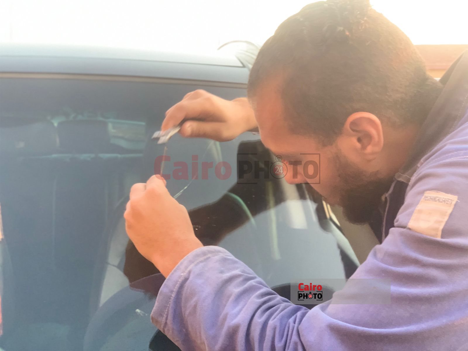 شاب يعمل في اصلاح زجاج السيارات ببورسعيد 