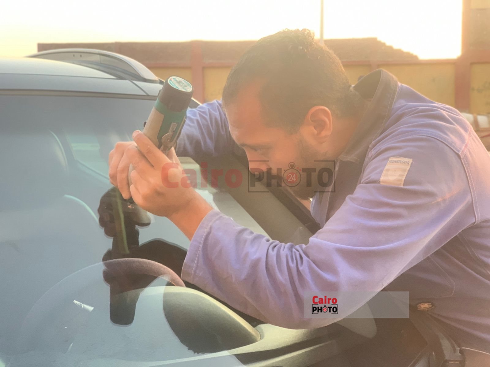 شاب يعمل في اصلاح زجاج السيارات ببورسعيد 