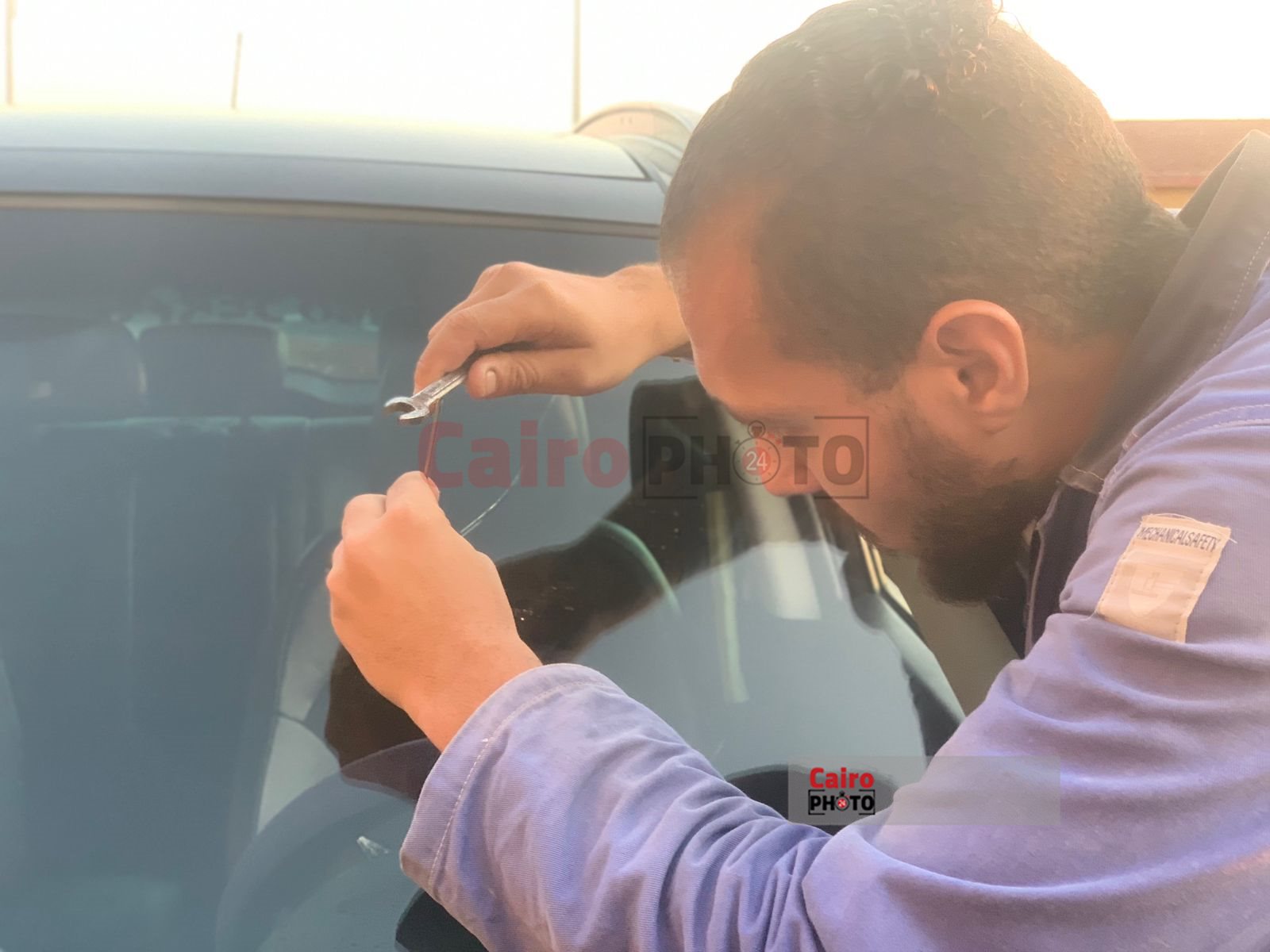 شاب يعمل في اصلاح زجاج السيارات ببورسعيد 
