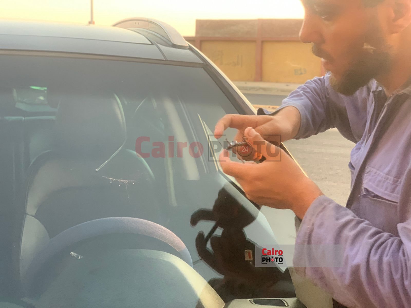 شاب يعمل في اصلاح زجاج السيارات ببورسعيد 