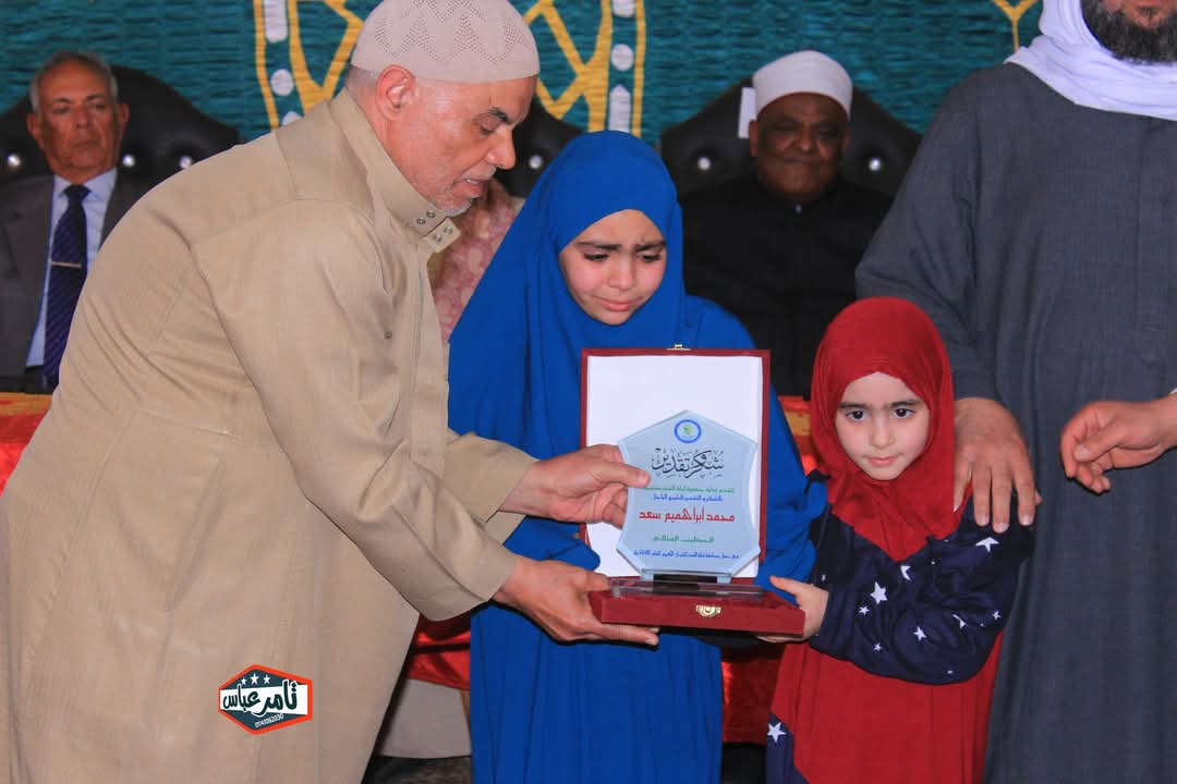 استلام الطفلة وشقيقتها درع والدها الراحل في حفل حفظة القرآن الكريم بالمنوفية