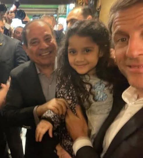 الرئيس الفرنسي يحمل طفلة مصرية بخان الخليلي