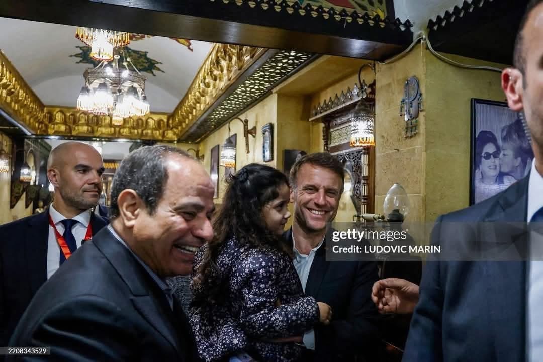 الرئيس الفرنسي يحمل طفلة مصرية بخان الخليلي