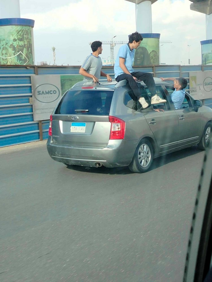 أطفال يستقلون سطح سيارة ملاكي بشارع التسعين في التجمع الخامس