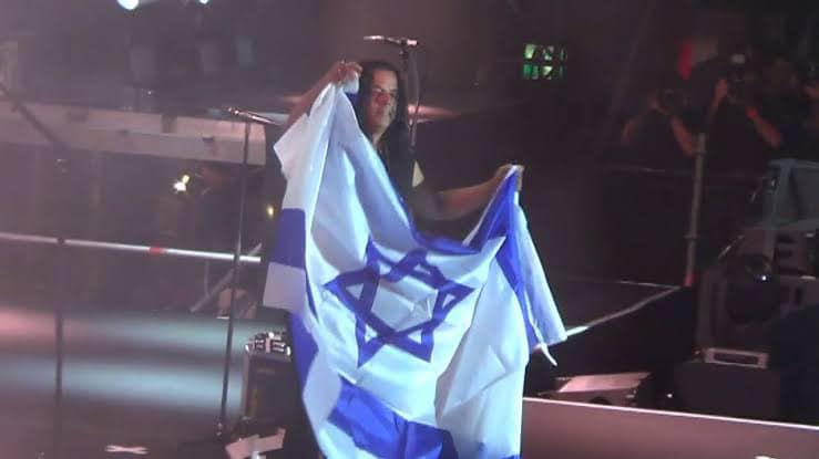 عضو فرقة سكوربيونز الألمانية يرفع علم إسرائيل في إحدى الحفلات