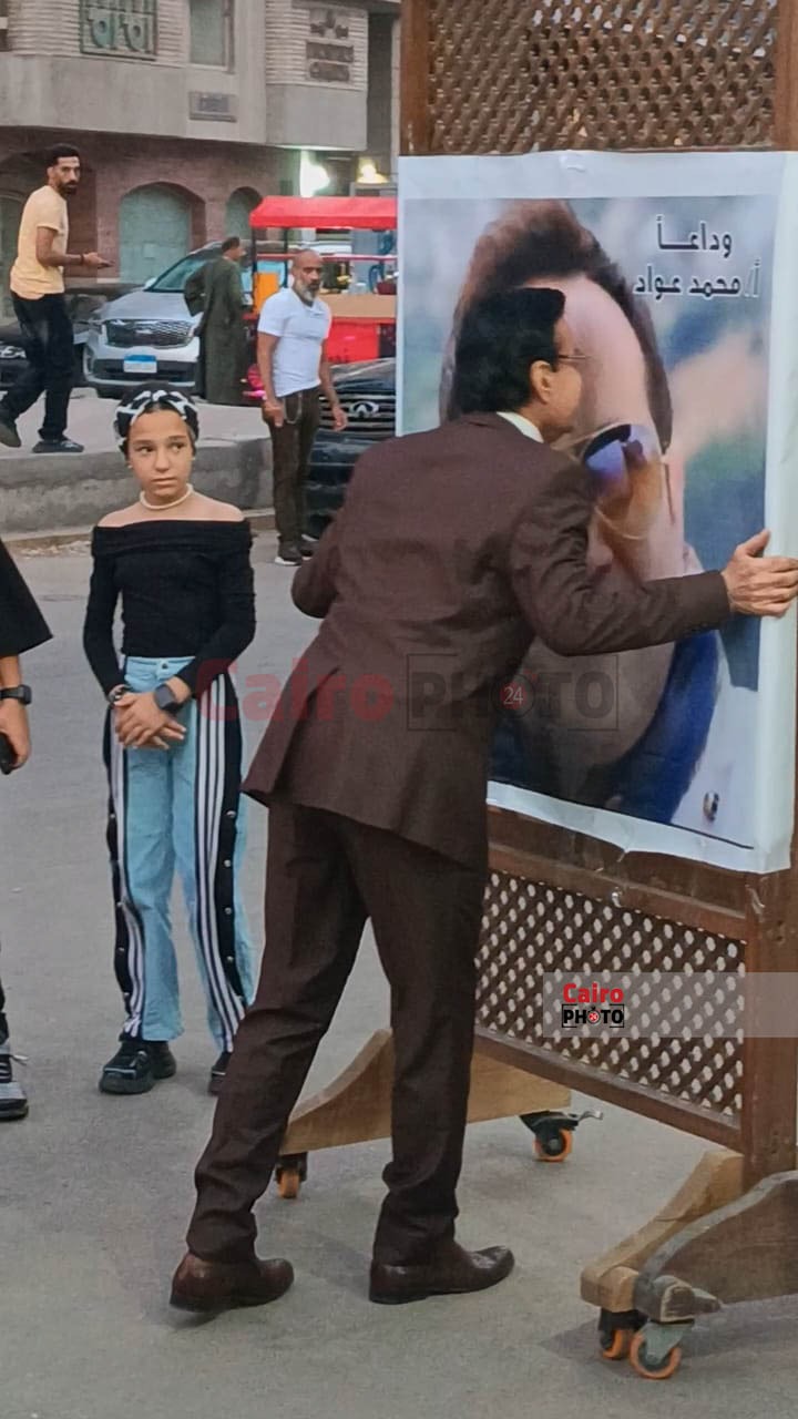 حلمي عبد الباقي يقبل صورة الراحل محمد عواد