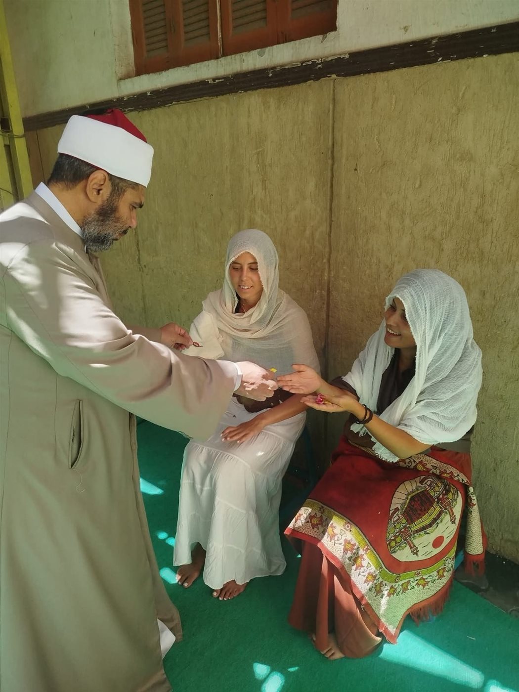 الشيخ يقدم الحلوى للسائحتين