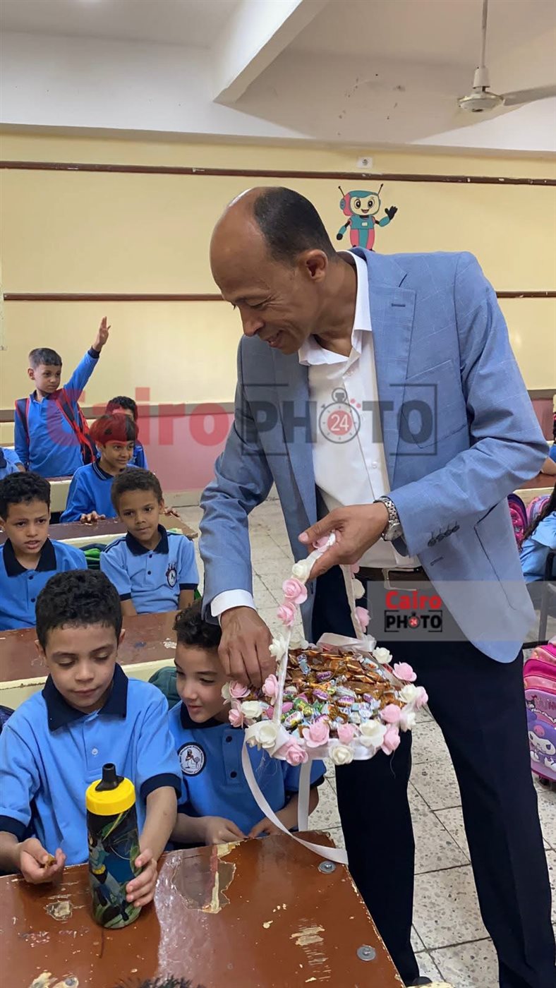مدير مدرسة يوزع الحلوى على الطلاب بأول يوم دراسي