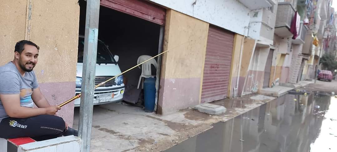 شباب يوثقون غرق شارع بمياه الصرف بإستخدام صنارة الصيد