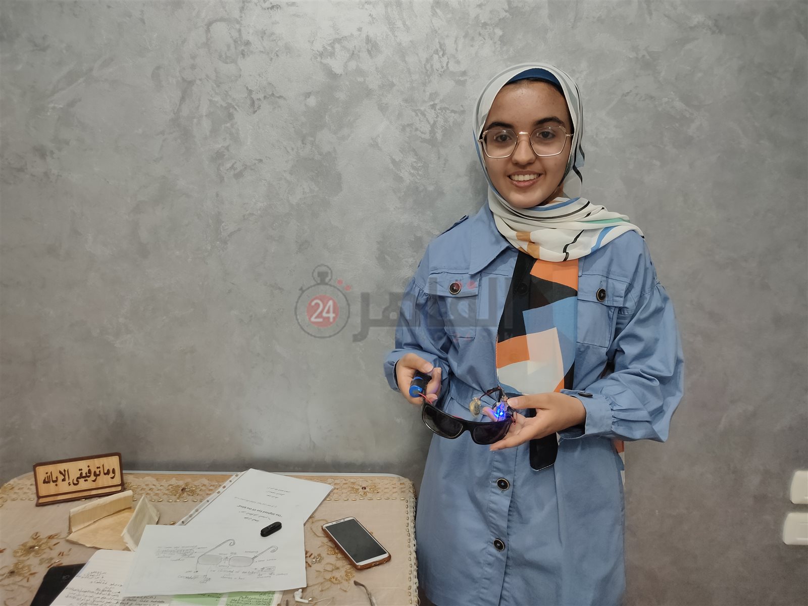 أمنية تحمل اختراعها في صورته التقريبية