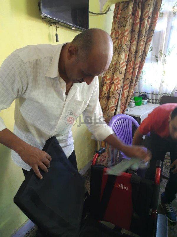 تسليم كرسي متحرك لشاب مصاب بالشلل 