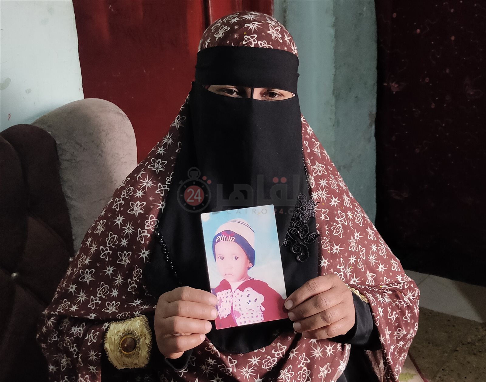 الأم تمسك بصورة طفلها