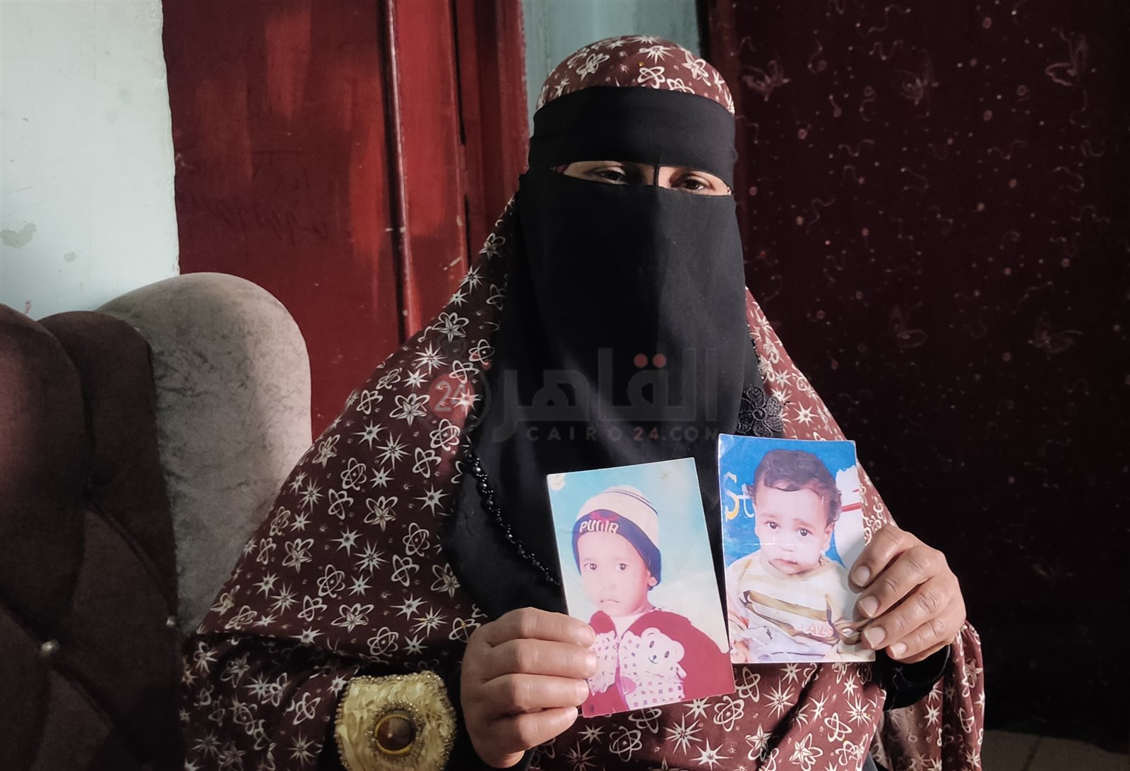 الأم تمسك بصور طفلها