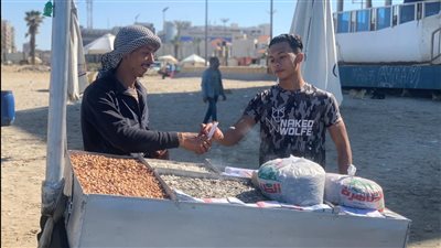 يمشي 40 كيلو يوميا.. قصة شاب يبيع التسالي على شاطئ بورسعيد | صور وفيديو