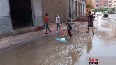 نزلوا الشارع بالمساحات.. الصغار يلهون بشوارع أسيوط بعد سقوط أمطار مفاجئة |صور وفيديو 