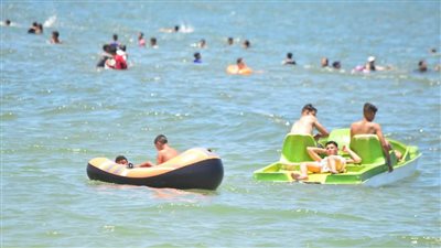 بدال وعوامة قارب.. شاطئ بورفؤاد يستقبل آلاف المصطافين في ثاني أيام العيد