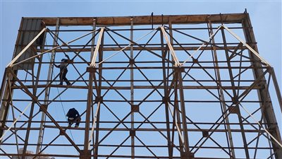 إزالة لافتة إعلانية مخالفة للشروط الفنية والتراخيص أعلى عقار بالقاهرة | صور