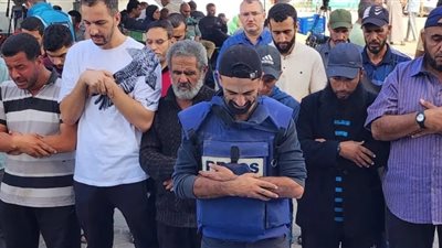 صحفي فلسطيني يودع أبناءه الأربعة بعد استشهادهم في القصف الإسرائيلي 