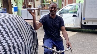 بضحكة مجلجلة ودراجة قديمة.. الطيب أشهر ديلفري للمشروبات الساخنة بالأقصر: بشتغل من 30 سنة