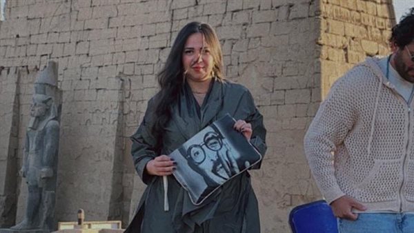 ايمي تحمل حقيبة عليها