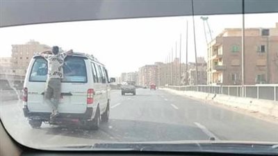 شخص يتشبث بظهر سيارة ويعرض حياته للخطر أعلى الدائري| صور 