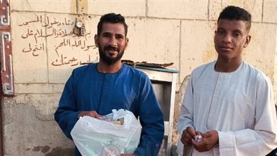 شاب قبطي يوزع الحلوى على الأهالي احتفالا بعيد الأضحى في قنا: أعيادنا واحدة