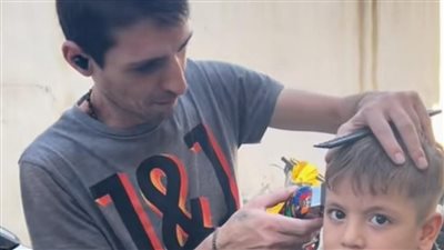 بعد تدمير محله.. لبناني يرفع شعار الحلاقة مجانا للصغار النازحين