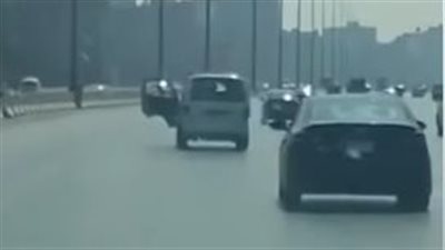 سائق ميكروباص يفتح باب سيارته أثناء القيادة على الطريق الدائري | صور