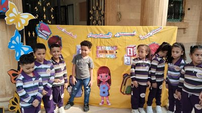 معلمو مدارس القاهرة يستقبلون الطلاب في أول أيام الدراسة بالورود والأعلام| صور
