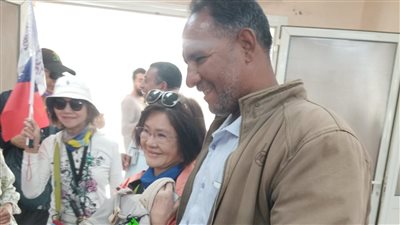 سائحون يحتفلون بـ مشرف أمن معبد إدفو بأسوان لإعادته حقيبة سائحة بعد فقدانها