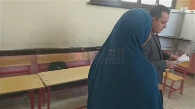 رئيس لجنة يساعد مسنة للإدلاء بصوتها في انتخابات مجلس النواب بطامية في الفيوم