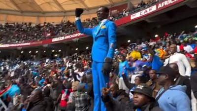 تخليدًا لذكرى باتريس لومومبا.. مشجع الكونغو يقف كتمثال طوال مباراة السنغال في أمم إفريقيا | صور