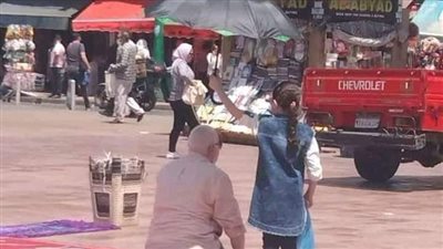 طفلة تحمل شمسية لوالدها اثناء الصلاة لحمايته من الشمس في الإسكندرية 