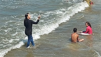 إقبال متوسط على شواطئ بورسعيد.. والعشرات يلتقطون سيلفي مع سفن عابرة لـ قناة السويس