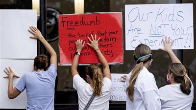 أطفالنا ليسوا فئران تجارب.. متظاهرون يشبهون الحكومة الأمريكية بطالبان