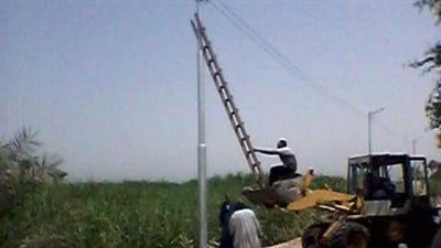 سلم أعلى سكينة لودر.. «محلية أبوتشت» تتجاهل إجراءات الأمان للعمال أثناء تركيب الكشافات