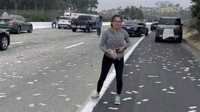 السماء تمطر نقودًا.. شاحنة تُسقط أموالا على طريق سريع والمارة يتنافسون لأخذها بأمريكا | صور
