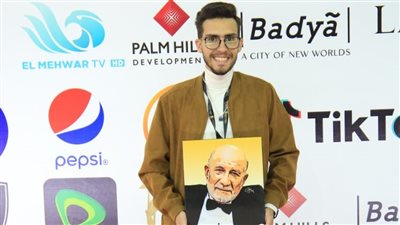 حفيد أحمد خليل يحمل بورتريه للفنان الراحل على ريد كاربت القاهرة السينمائي