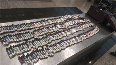 ضبط راكبين بالمطار حاولا تهريب كمية زيت شيش وهواتف حديثة | صور