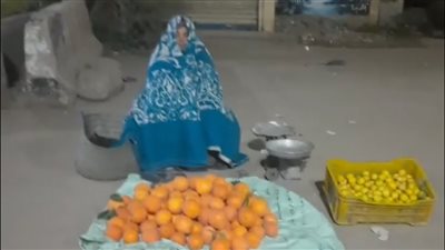 سيدة البرد.. الحاجة عطيات تجلس لبيع البرتقال للإنفاق على أولادها بعد مرض الزوج