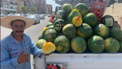 بصورة فنانك المفضل.. بائع بطيخ في بورسعيد يبتكر طريقة جديدة لزيادة مبيعاته.. والزبائن: أول مرة نشوف بطيخة زرقاء