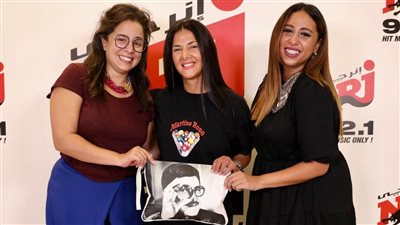 دنيا سمير غانم تحمل بورتفيه عليه صورة والدها خلال استضافتها في راديو إنرجي