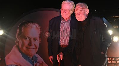 المخرج بيلا تار يشيد بـ بوستر حسين فهمي ويلتقط صورة سيلفي أثناء الخروج من الافتر بارتي بمهرجان القاهرة السينمائي